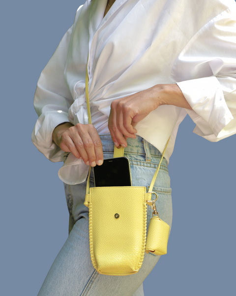 woman wearing a yellow crossbody bag for her phone 
